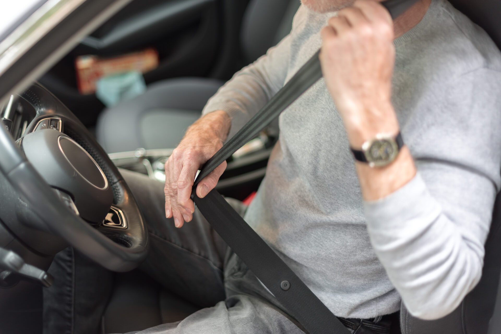 Illustration d'un jeune homme attachant sa ceinture de sécurité dans une voiture, symbolisant la réforme du permis de conduire et ses implications pour les jeunes conducteurs et les entreprises.