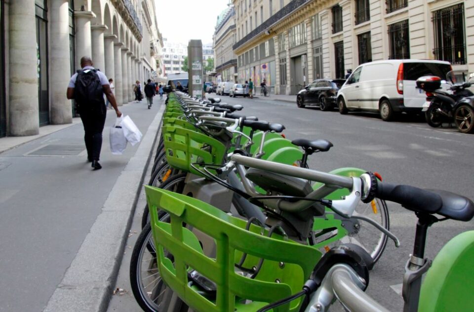 Une station de vélos en libre-service au cœur de la ville, symbole de mobilité partagée et durable pour les entreprises.