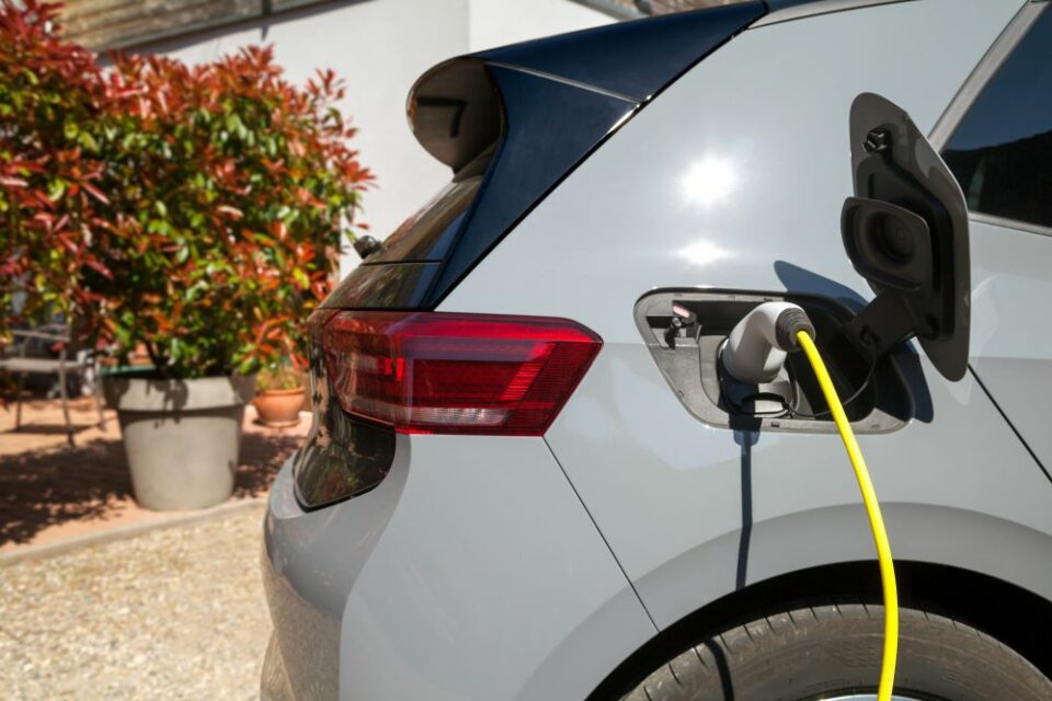 Une voiture électrique est branchée à une borne de recharge installée à domicile, illustrant les droits des salariés en matière de mobilité professionnelle selon le Code du travail.