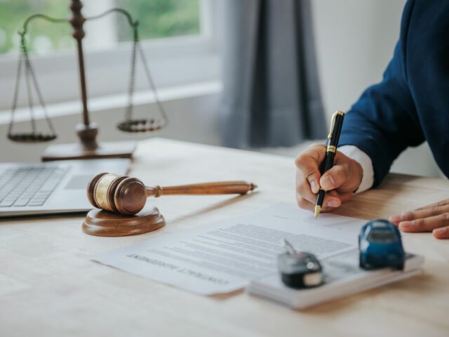 Un employé examine attentivement des textes de loi sur son bureau.