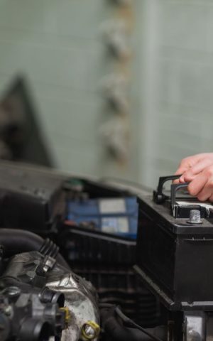 Garagiste qui met en place une batterie dans un voiture électrique.