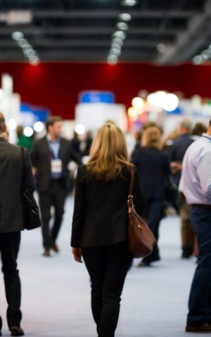 Une femme de dos explore les stands du salon FlotAuto 2025, un événement dédié à la gestion de flotte automobile, à l’électrification et aux nouvelles solutions de mobilité d’entreprise.